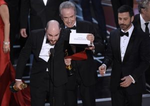 Jordan Horowitz, productor de "La La Land", muestra el sobre que reveló que "Moonlight" fue la verdadera película ganadora de los Oscar el domingo 26 de febrero de 2017 en el Teatro Dolby en Los Angeles. El presentador Warren Beatty y el anfitrión Jimmy Kimmel lo ven a la derecha. (Foto Chris Pizzello/Invision/AP)